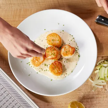 Seared Scallops with Leeks and Tarragon in white bowl