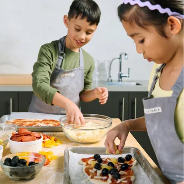 boy and girl making pizzas in Sur La Table kitchen