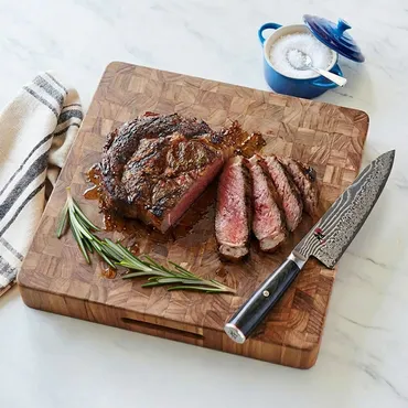Bistecca All Fiorentina (Steak Florentine) on wooden cutting board with rosemary